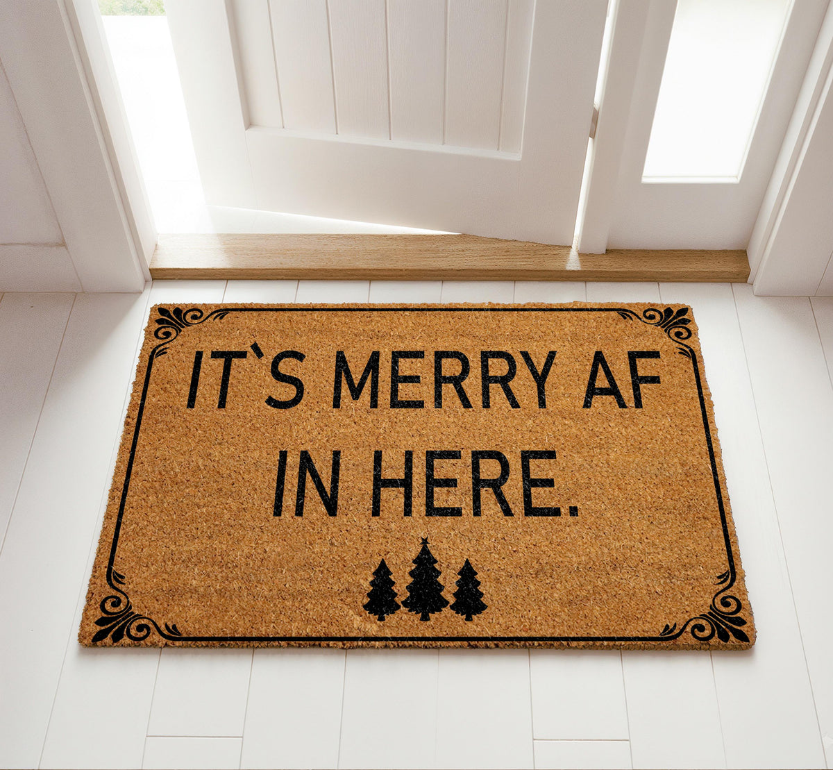 Doormat with "It’s merry AF in here" block lettering and three trees