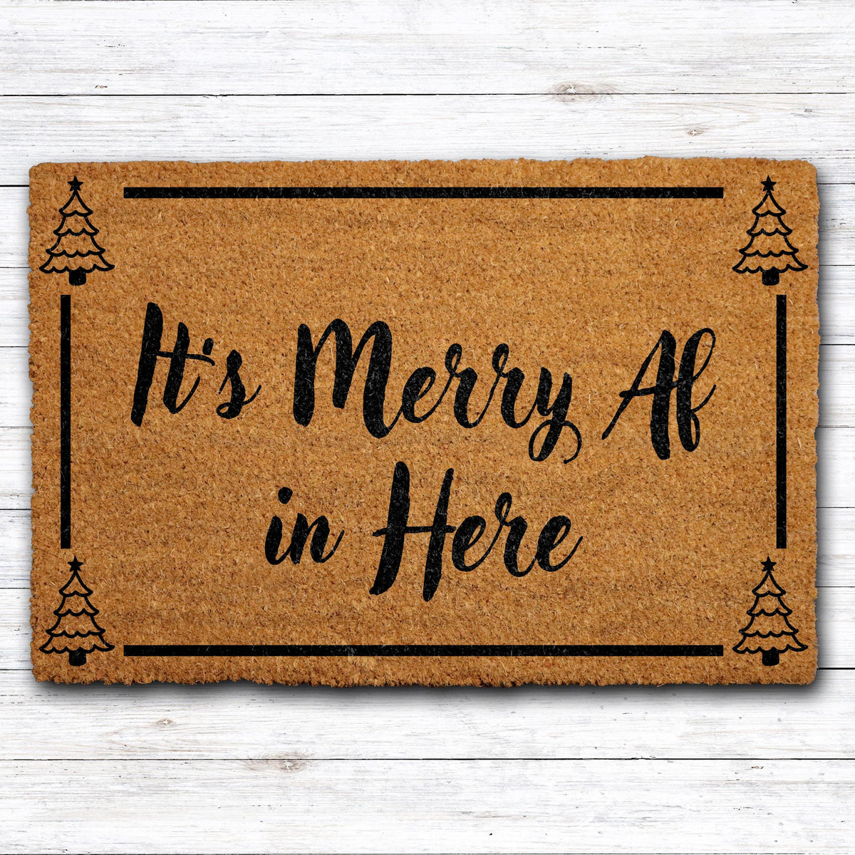 Doormat with "It’s merry AF in here" script lettering and a tree border
