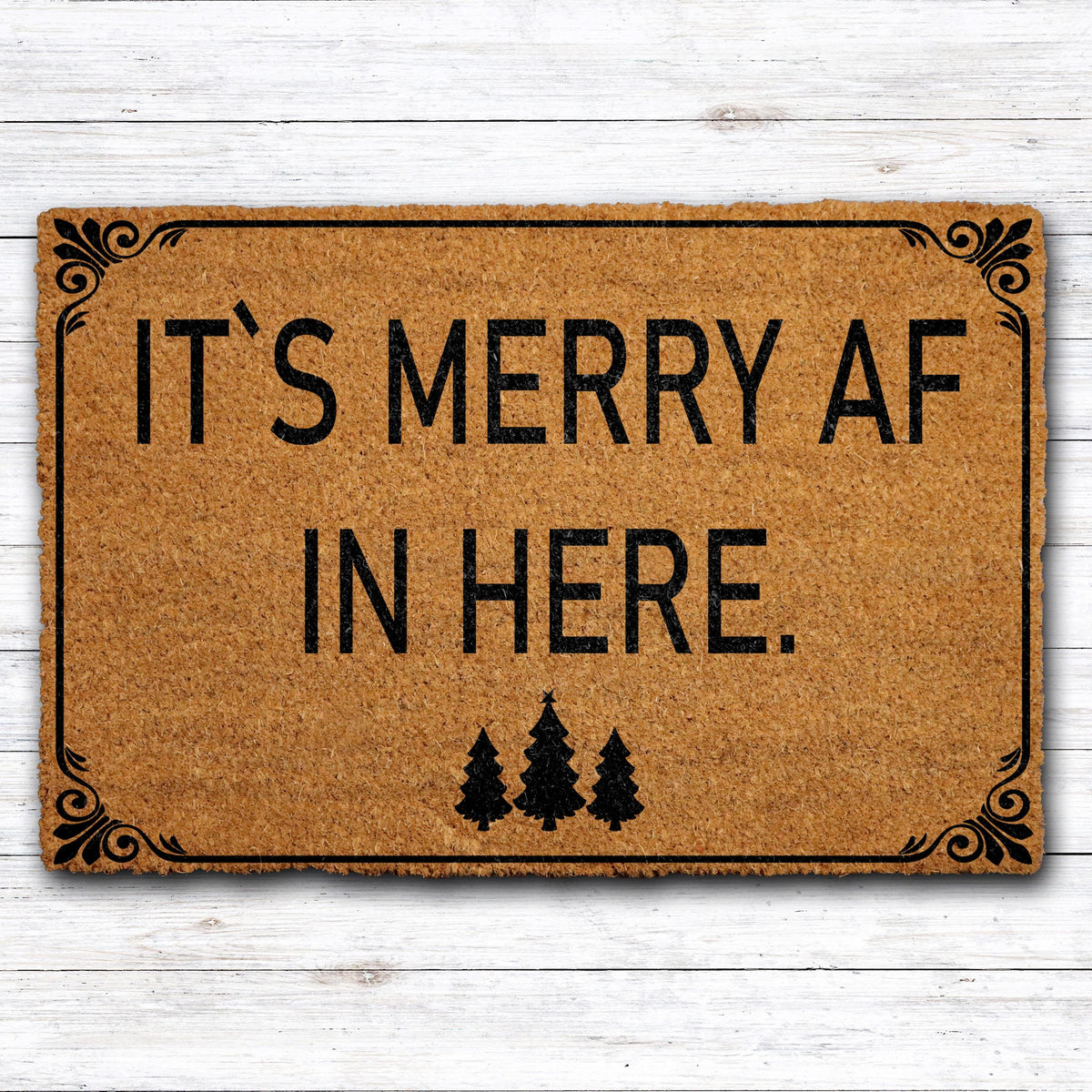 Doormat with "It’s merry AF in here" block lettering and three trees