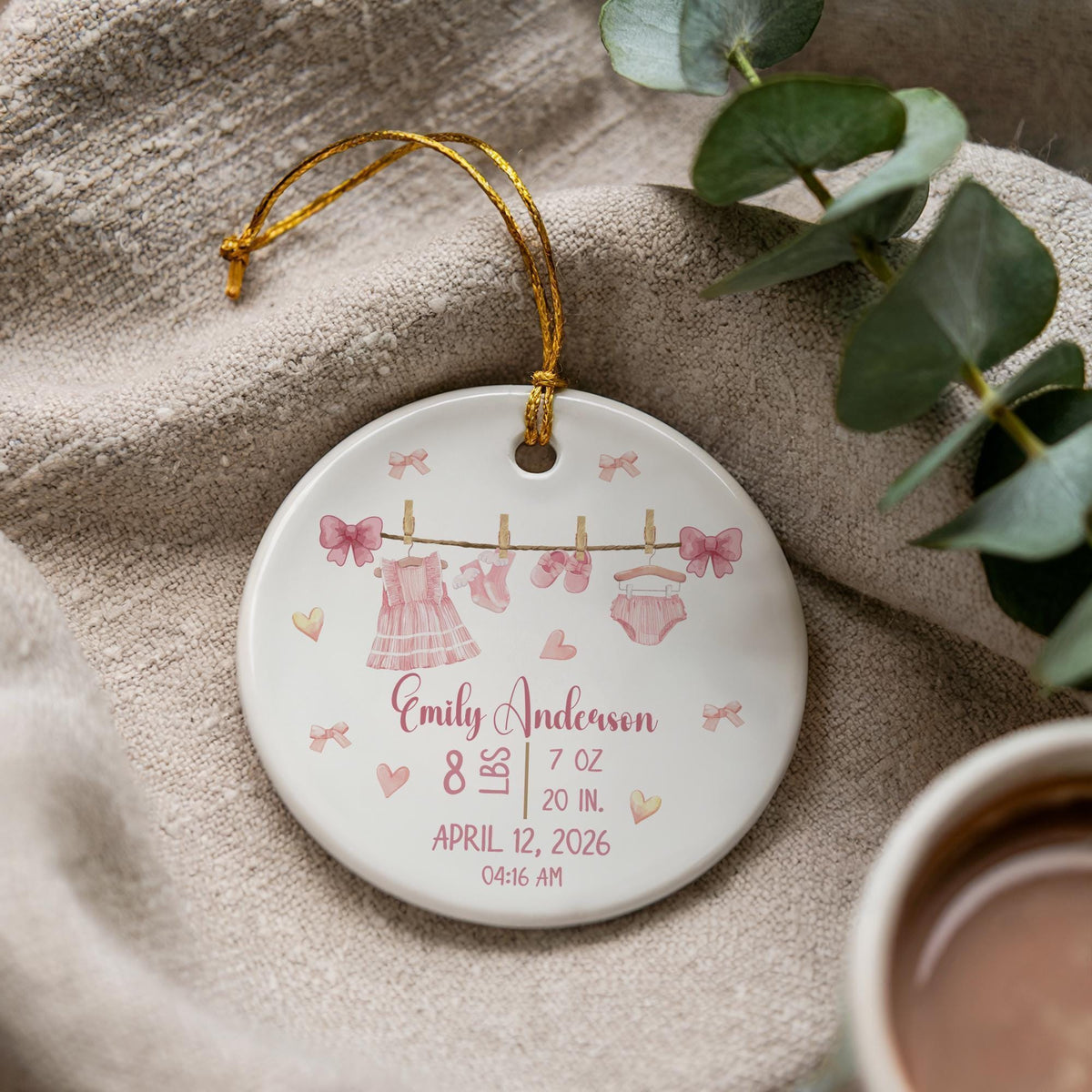 Round ornament with baby clothes on a line and personalized birth details